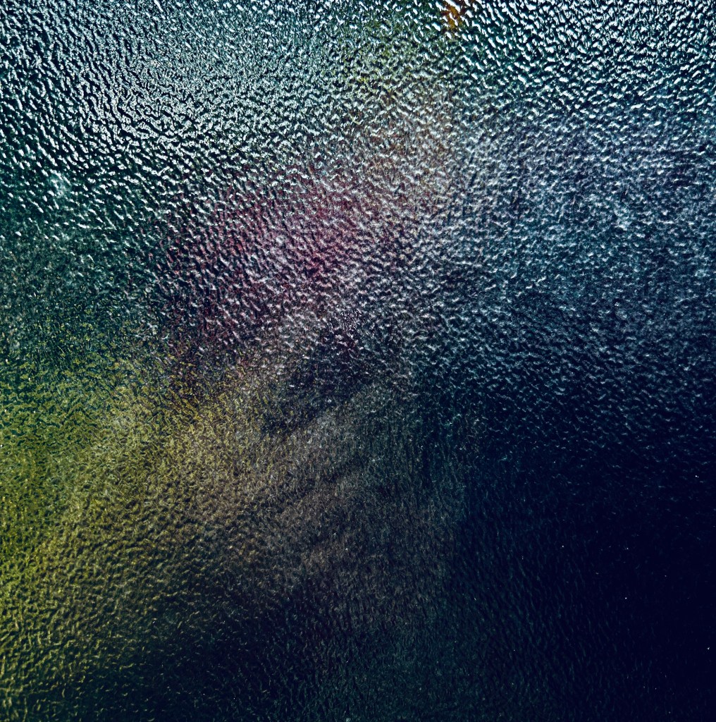 Hand visible through pebbled glass