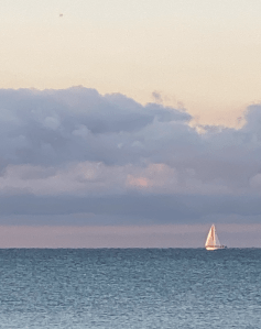 Dark clouds with sailboat on rippling water