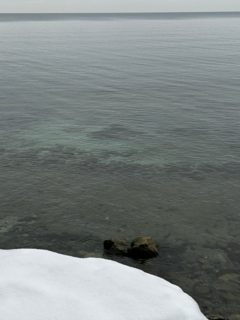 Snow beside a cold lake